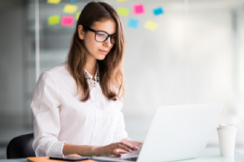 femme daffaires-succès-travaillant-ordinateur-portable-son-bureau-habillé-blanc-vêtements